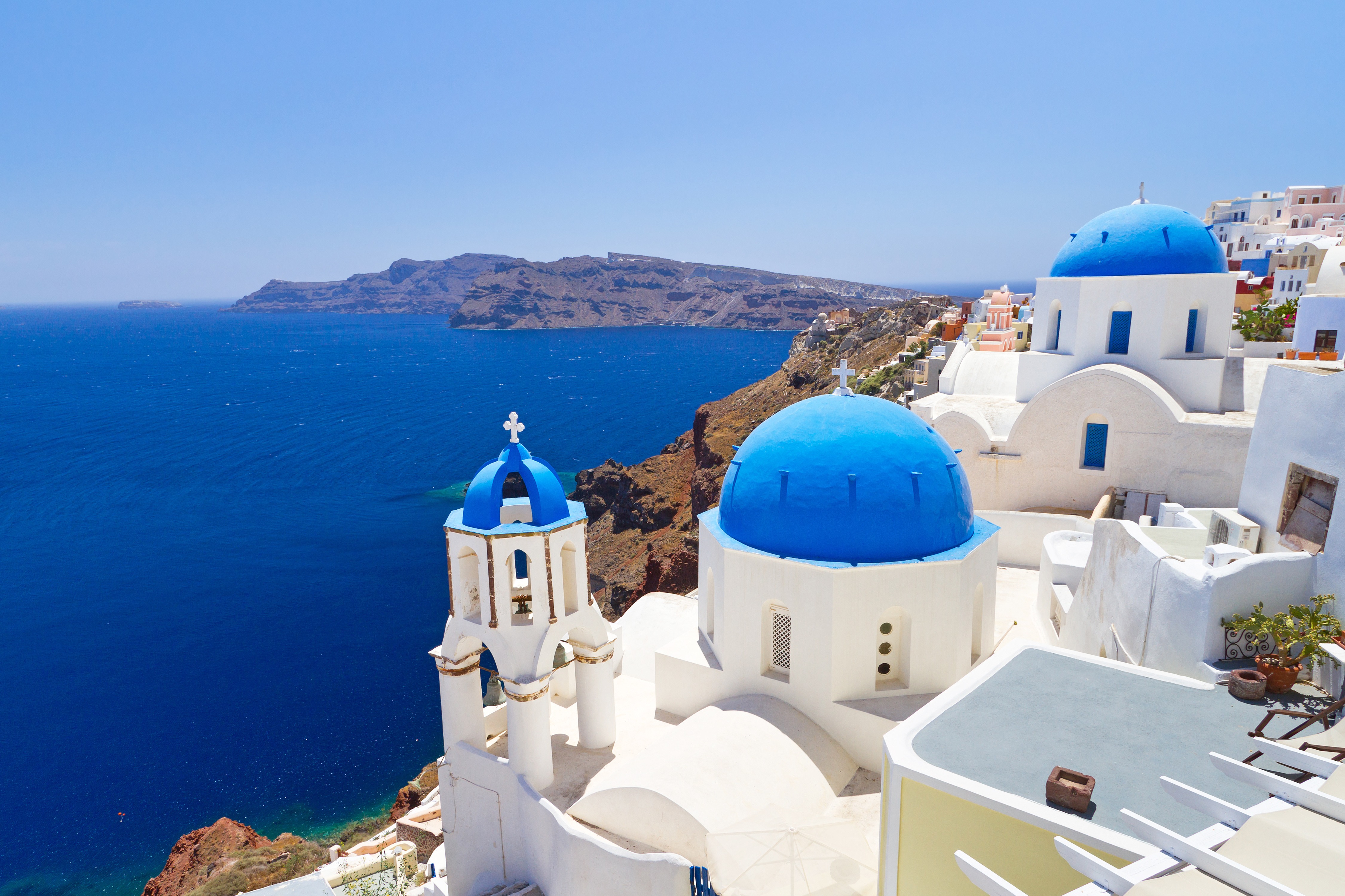 Iconic blue-domed churches of Santorini overlooking the Aegean Sea