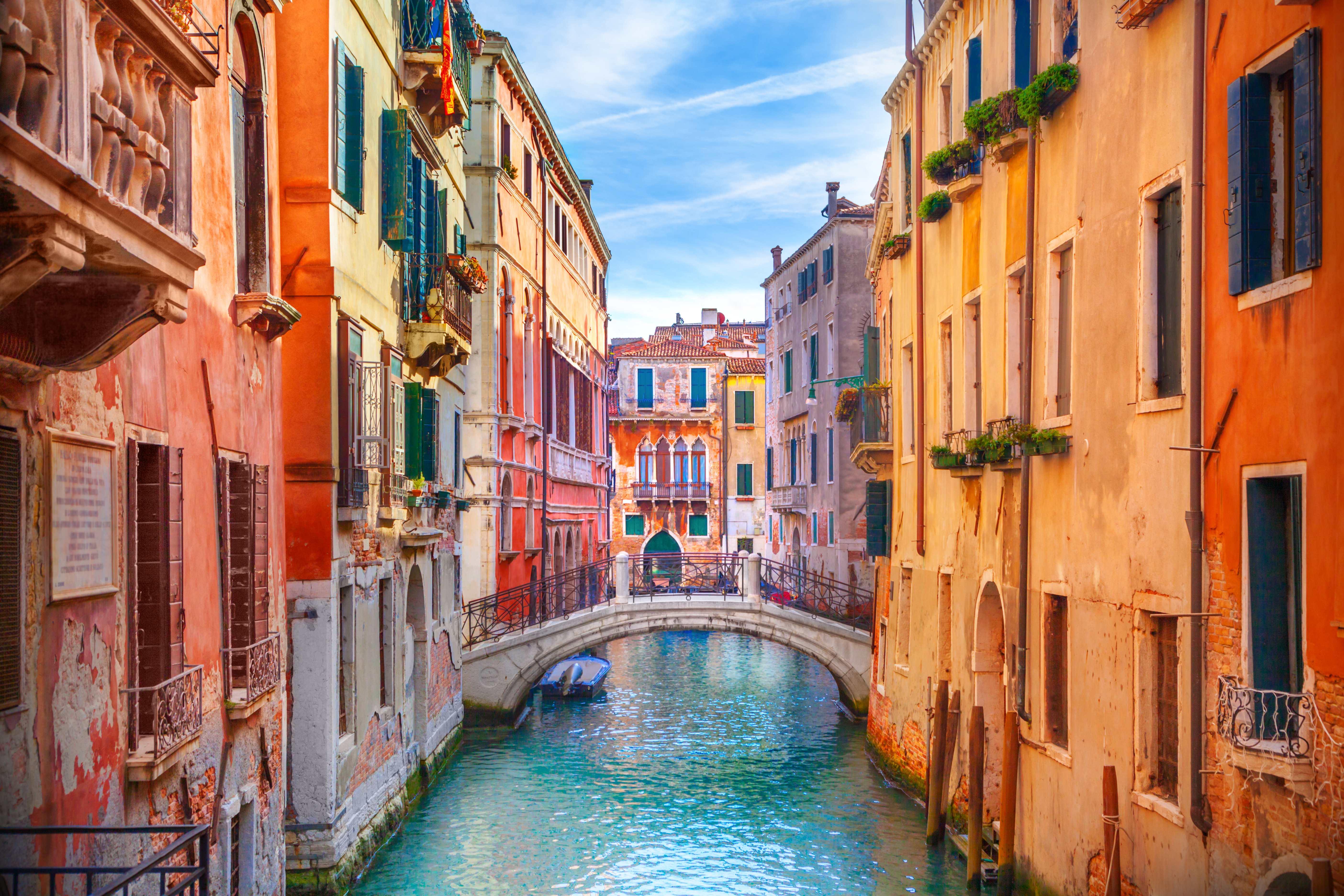 Colorful Venice canal with traditional architecture and stone bridge